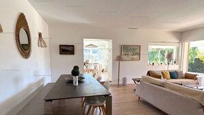 Ein modernes Wohnzimmer mit Essbereich, einer Couch und einem Esstisch mit Stühlen.