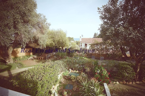 A garden with a pathway, benches, and a small pond.