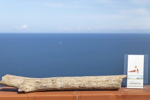 A wooden log and a sign with a beach scene. - Sardinia Re - Casa Bellavista Panoramic View (Castelsardo)