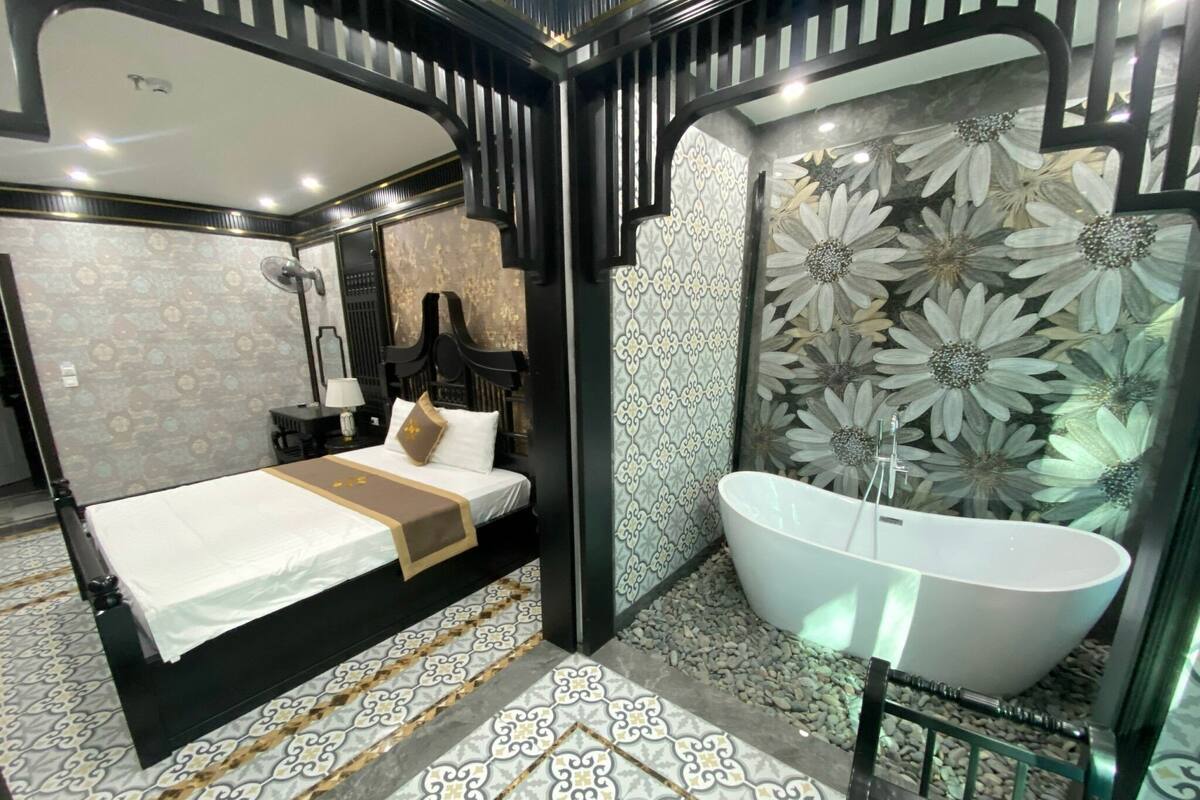 Une chambre à coucher moderne avec un grand lit, une coiffeuse avec un miroir et une baignoire sur pieds.