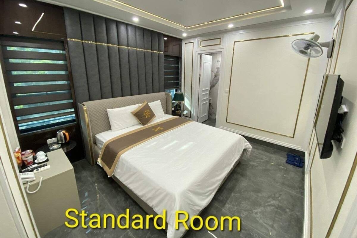 Une chambre standard équipée d’un lit, d’une table de chevet, d’une lampe et d’une armoire.