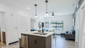 Een moderne keuken met een centraal eiland, een ingebouwde vaatwasser en een plafondventilator.