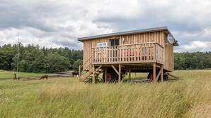 Eine Holzhütte mit Balkon, Satellitenschüssel und Fenster.