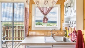 Eine Küche mit Fenster, Spüle und Geschirrgestell.