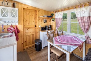 Un intérieur en bois comprenant une cuisine, une table à manger et des chaises.