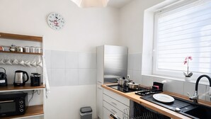 Eine moderne Küche mit Backofen, Spüle und einem Fenster mit Jalousien.