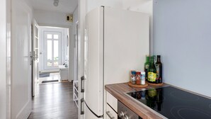 Eine Küche mit Kühlschrank, Herd und verschiedenen Flaschen auf der Arbeitsfläche.