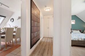 A room with a dining area, a bookshelf, a wardrobe, and a bed.