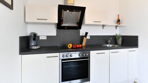 A modern kitchen with a built-in oven, a coffee machine, and a sink.