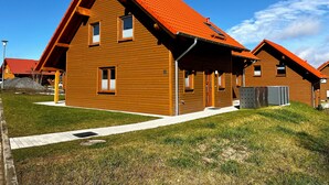 Ein modernes Holzhaus mit Satteldach und überdachter Veranda.