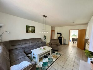 Una sala de estar con sofá, una mesa de centro, chimenea y comedor.