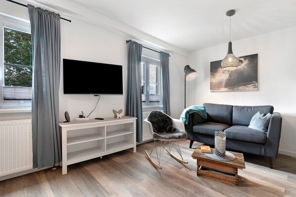 A modern living room with a TV, sofa, and a painting.