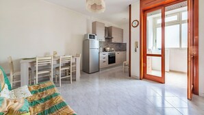 A compact living space with a kitchenette, a dining area, and a bedroom. - Porta Di Mare Apartment With Balcony and A/C (Nardò)