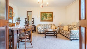 A living room with a dining table, chairs, a sofa, and a chandelier. - Porta Di Mare Apartment With Balcony and A/C (Nardò)