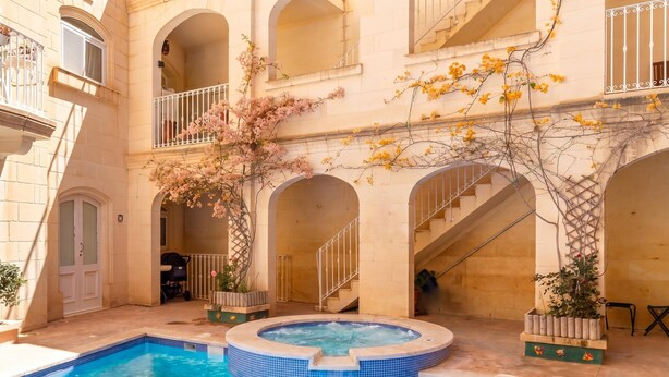 A courtyard with a swimming pool, arched balconies, and a staircase. - Maisonnette & Pool Ta'cenc Sannat Gozo (Sannat)