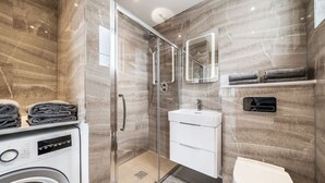 Une salle de bain moderne avec une douche à parois de verre, un lavabo intégré et des toilettes.
