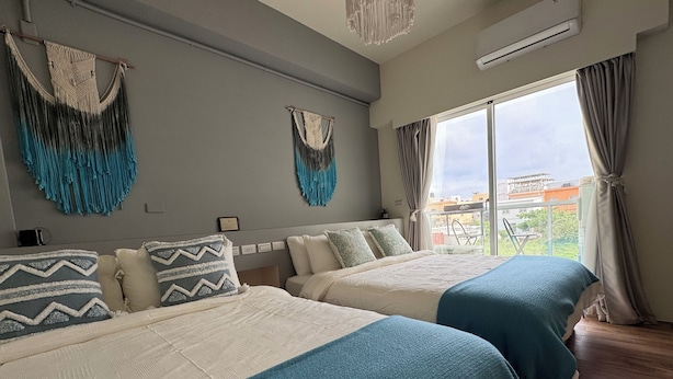 A hotel room with two beds, a balcony with a view, and a ceiling fan. - Lose track of time (Magong)