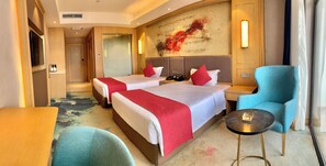 A hotel room with two beds, a seating area, and a wall with a musical note design.