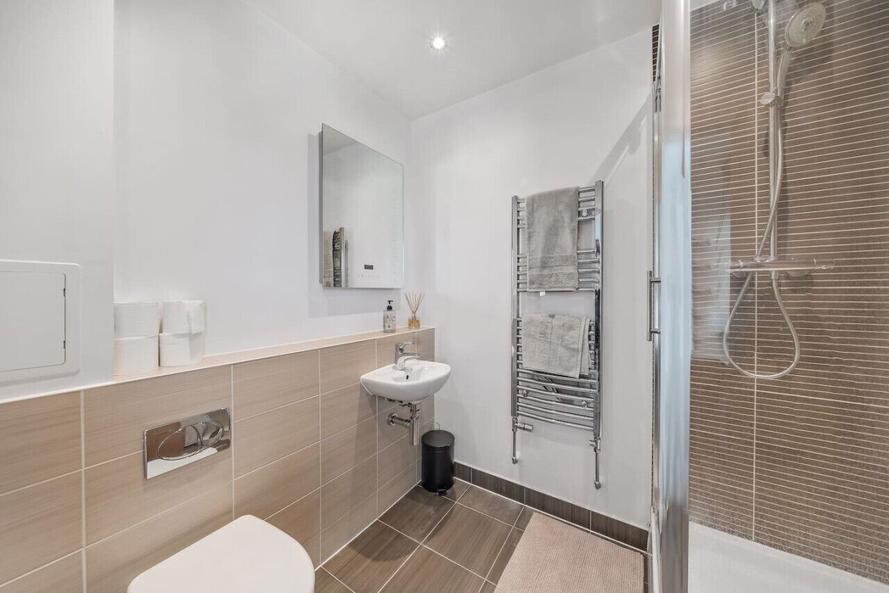 A modern bathroom with a toilet, sink, and shower.