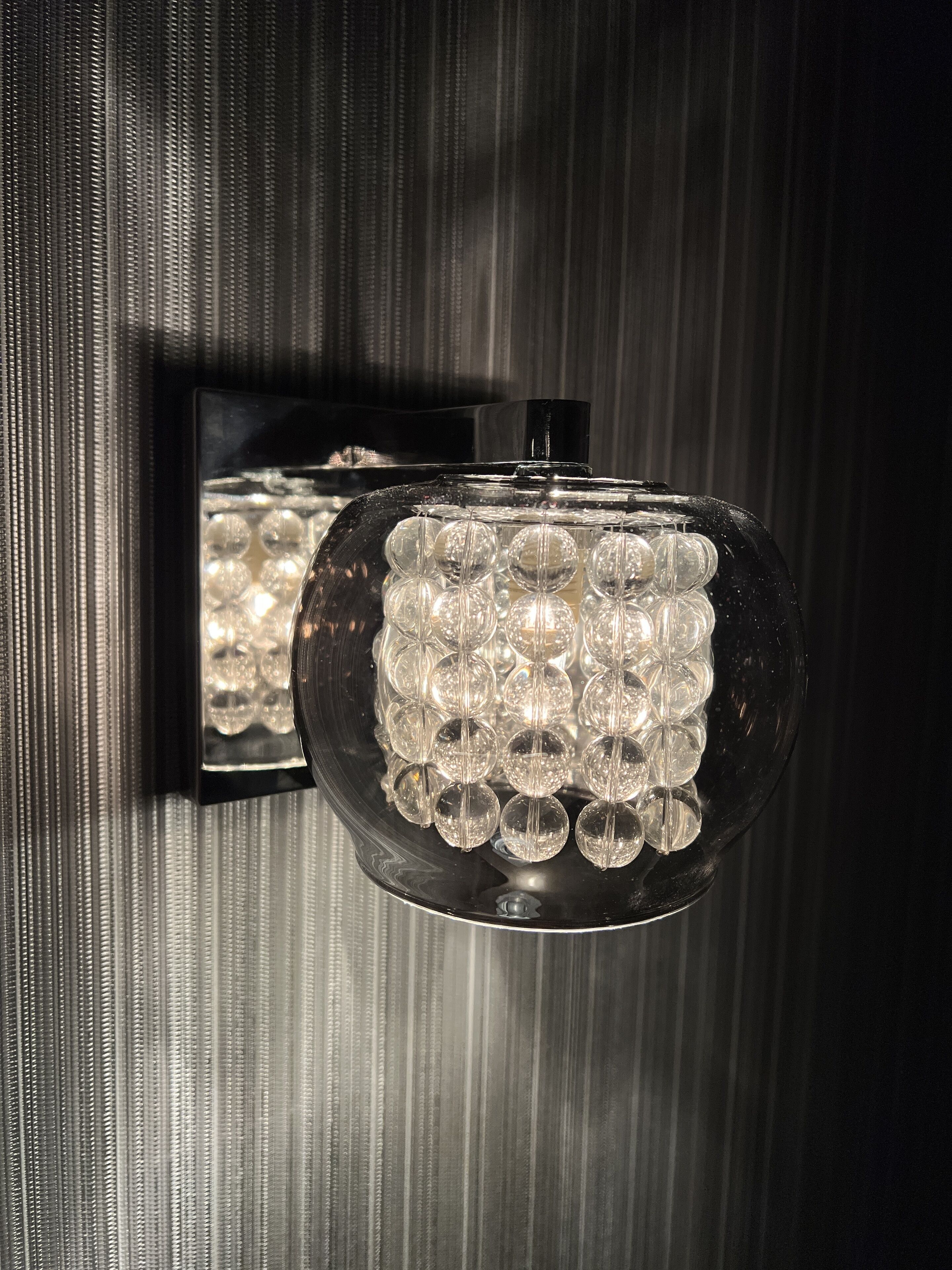 A wall-mounted light fixture with multiple clear glass bulbs.