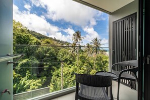 A balcony with a view of a lush green landscape and a clear sky. - The Panora apartments by NLA (Choeng Thale)