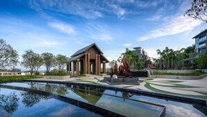 A modern resort with a swimming pool, a pavilion, and a landscaped garden. - The Panora apartments by NLA (Choeng Thale)