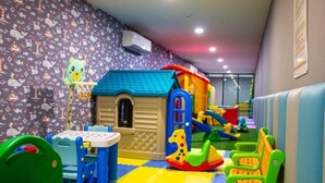 A children's play area with a playhouse, slide, and various toys. - The Panora apartments by NLA (Choeng Thale)