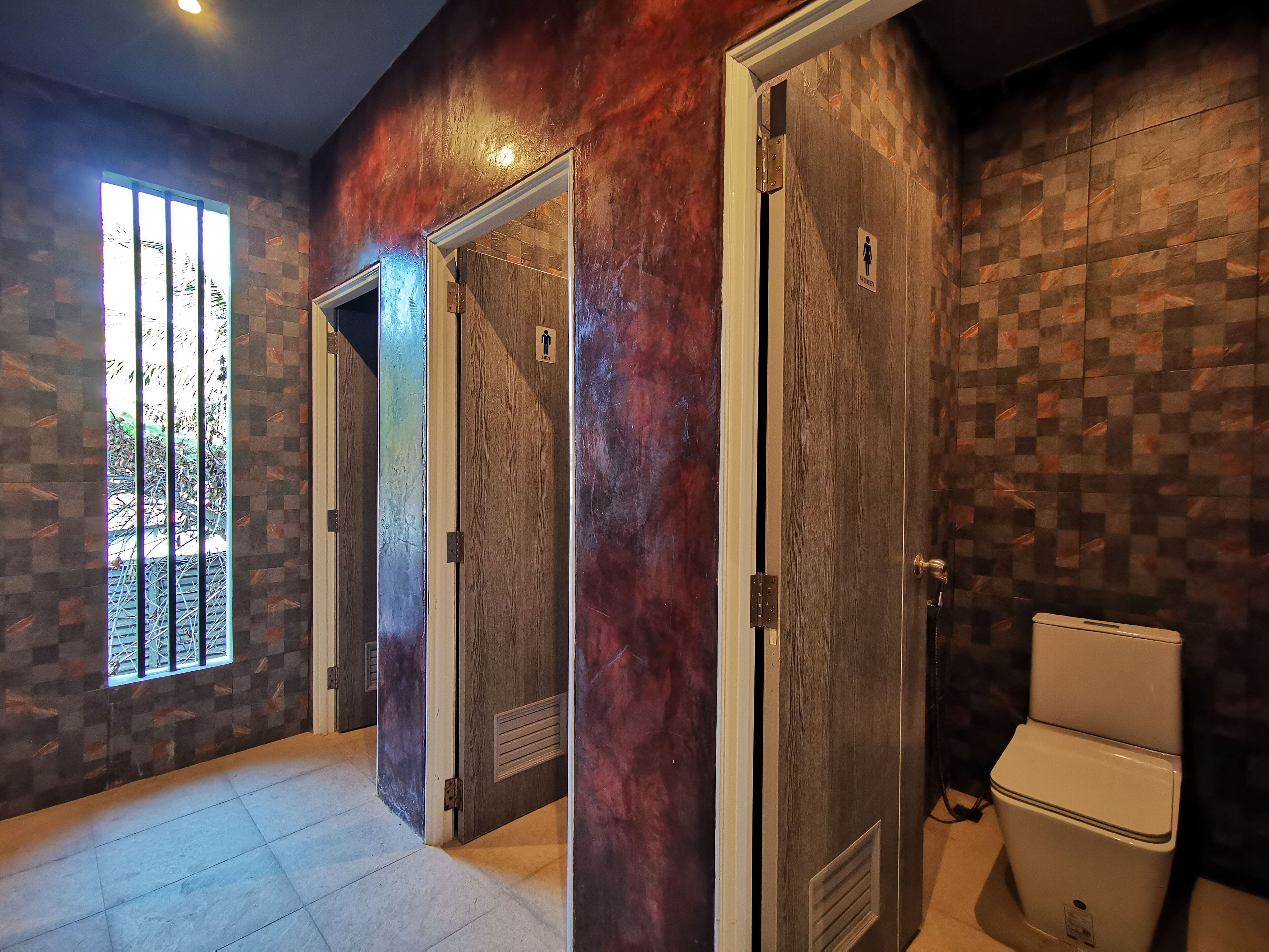Une salle de bain avec des toilettes, un lavabo et une fenêtre.