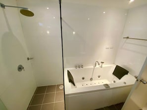 A modern bathroom with a glass-enclosed shower, a freestanding bathtub, and a glass door.