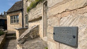A stone cottage with a sign reading "Sundial Cottage." - Luxury Cosy Cottage In Magical Bibury (Bibury)