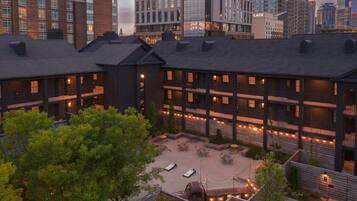 A multi-story building with a courtyard featuring outdoor seating and string lights.