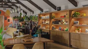A modern interior with a wooden reception desk, seating area, and shelves stocked with products.