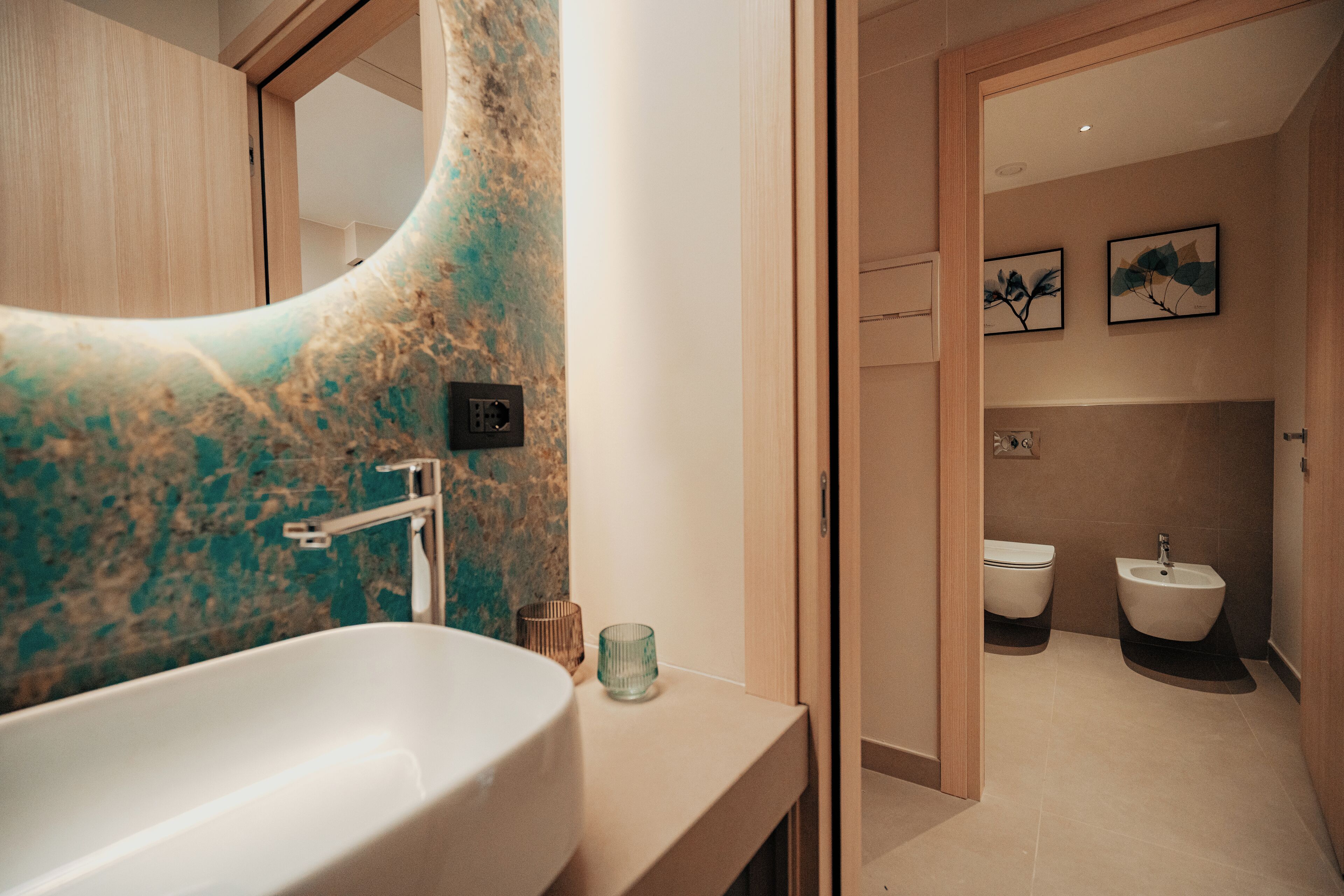 A modern bathroom with a large sink, a bidet, and a toilet.