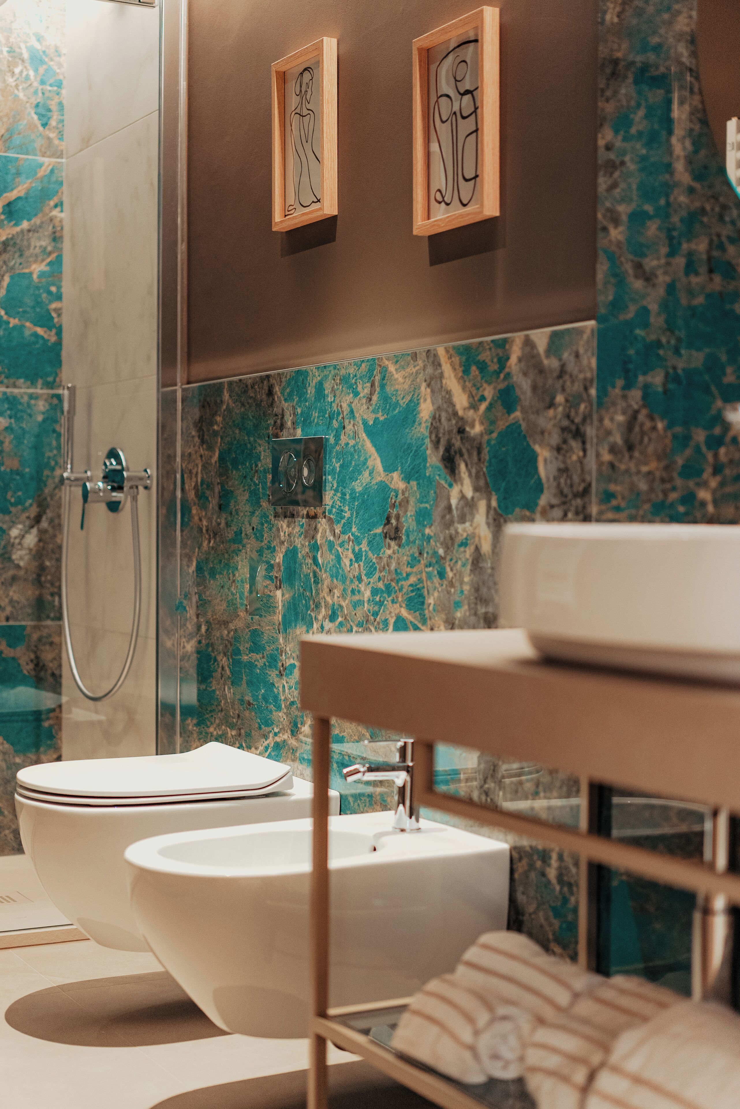 Un baño moderno con salpicadero de mármol, inodoro independiente, lavabo y ducha.
