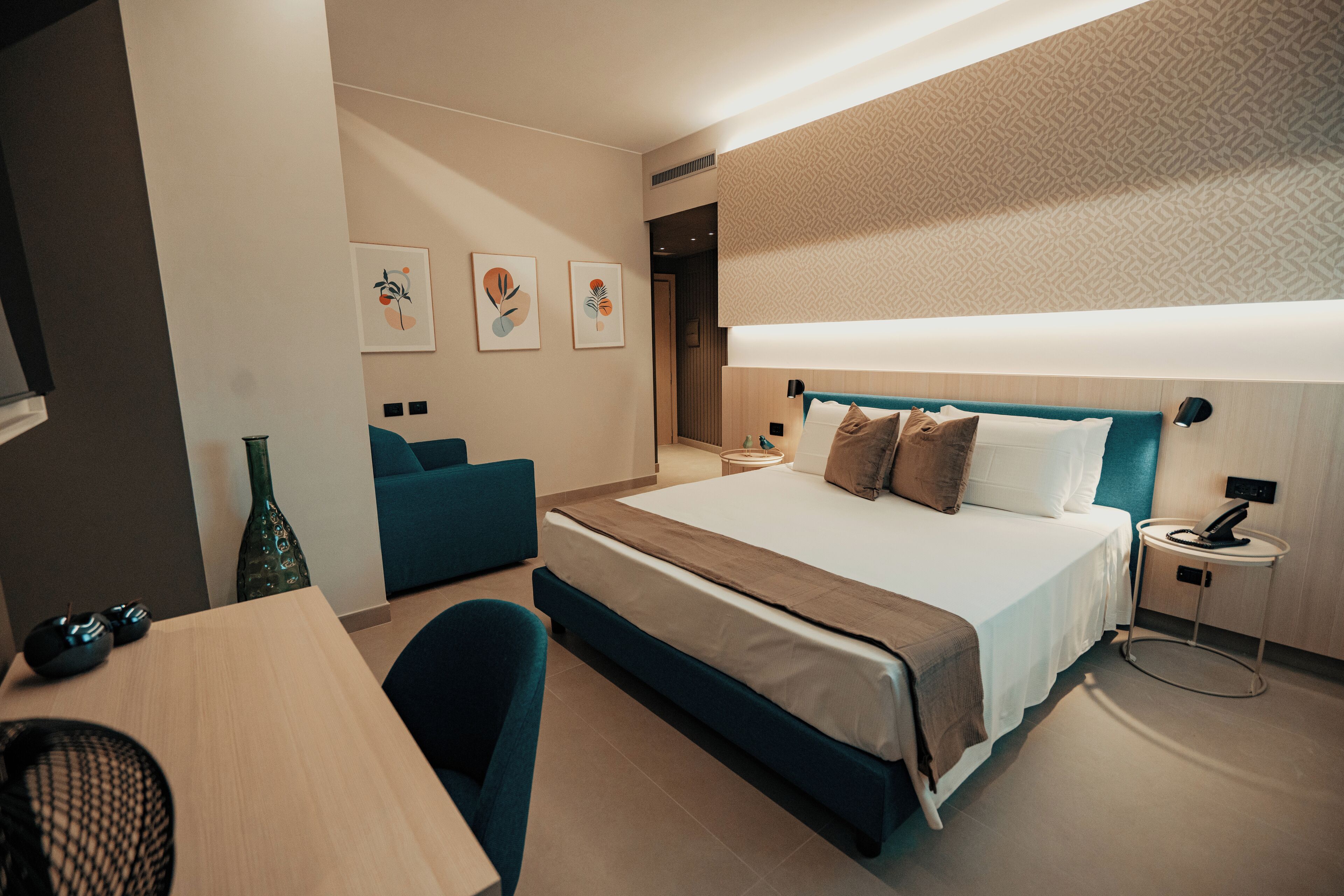 Una habitación de hotel moderna con una cama grande, un escritorio y un sofá.