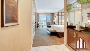 Ein Hotelzimmer mit einem Bett, einem Schreibtisch, einem Stuhl, einem großen Fenster und Blick auf die Stadt.