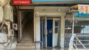 A staircase leading to a hotel entrance with a sign for OYO Hotel Mannat and a Bank of Maharashtra sign above. - Hotel Mannat International (New Delhi)
