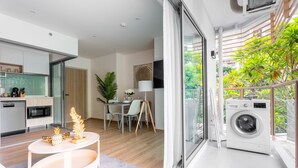 A modern apartment with a kitchen, dining area, and balcony with a washing machine. - Phyll Phuket by NLA (Wichit)