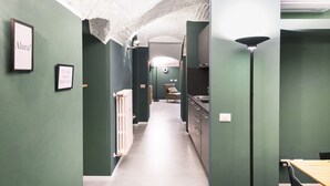 A narrow hallway with green walls, a radiator, and a sink area. - Easylife - Elegance in the Isola district (Milano)