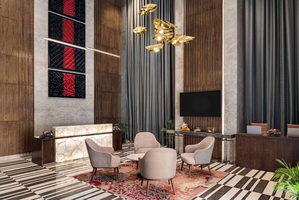 A modern lobby with a reception desk, seating area, and a large flat-screen TV. - Ramada by Wyndham Gorakhpur Gorakhnath Mandir Road (Gorakhpur)