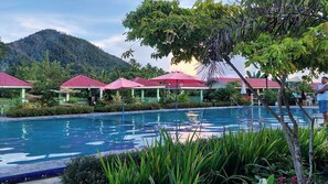 A pool area with a mountain backdrop, covered seating areas, and lush greenery. - Mariden Resort & Homestay Siargao (Del Carmen)