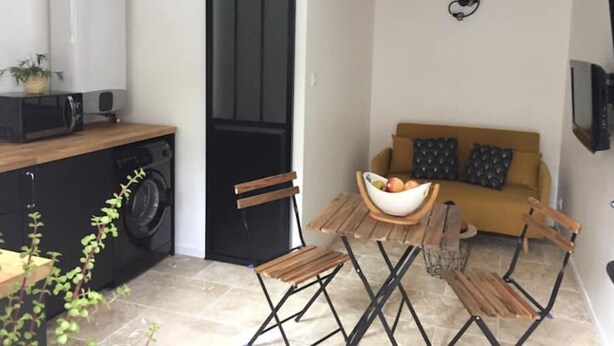 A compact living space with a kitchenette, a dining area, and a sofa. - Studio Moderne (Saint-Symphorien-d'Ozon)