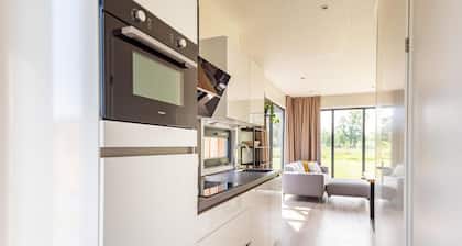 The 6-person holiday villa Amalia with a private sauna has a spacious living room, an open kitchen, three bedrooms, and a spacious terrace.