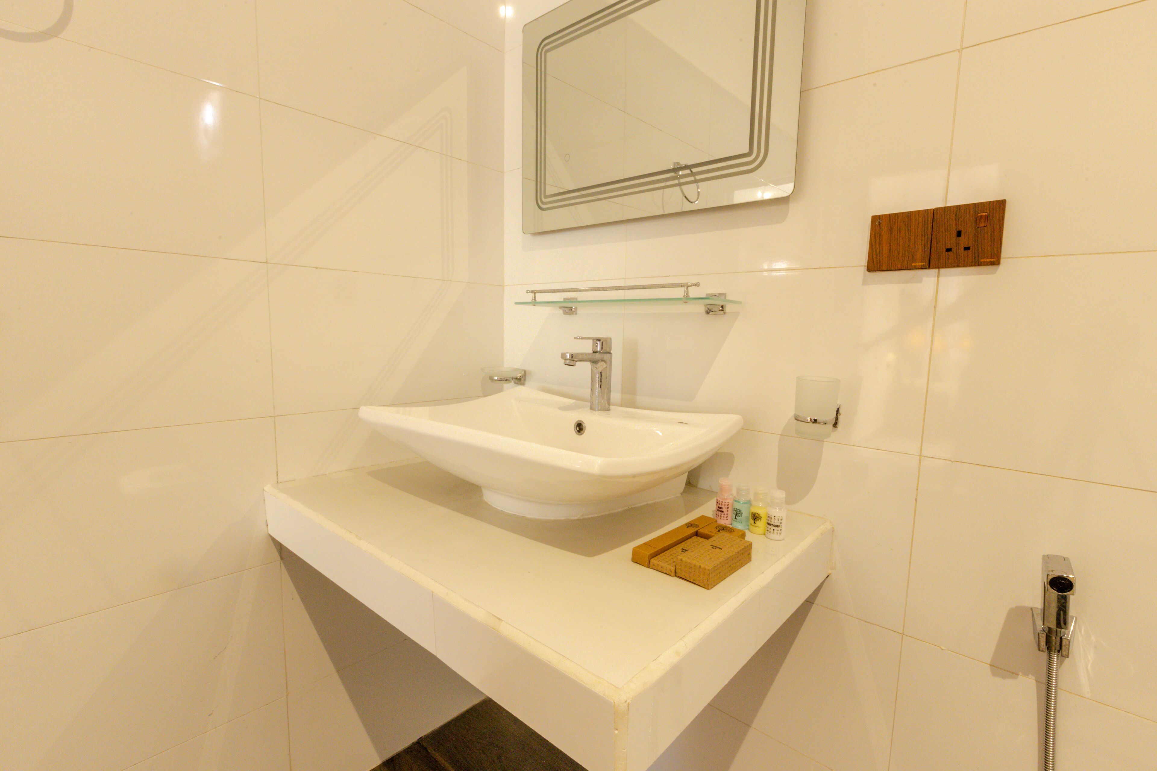 Une salle de bain moderne avec un lavabo blanc, un miroir et une douche.