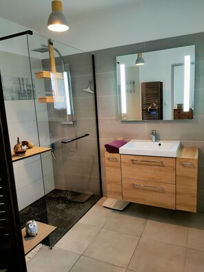 A modern bathroom with a glass shower enclosure, a wooden vanity with a sink, and a large mirror. - Villa sur Jardin Clos, Piscine et Terrasses, 7 Couchages, Environnement Calme (Trans-en-Provence)