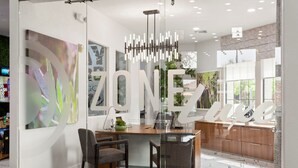 A modern kitchen with a central island, two chairs, and a hanging light fixture. - CozySuites Glendale with pool  04 and 18 (Glendale)