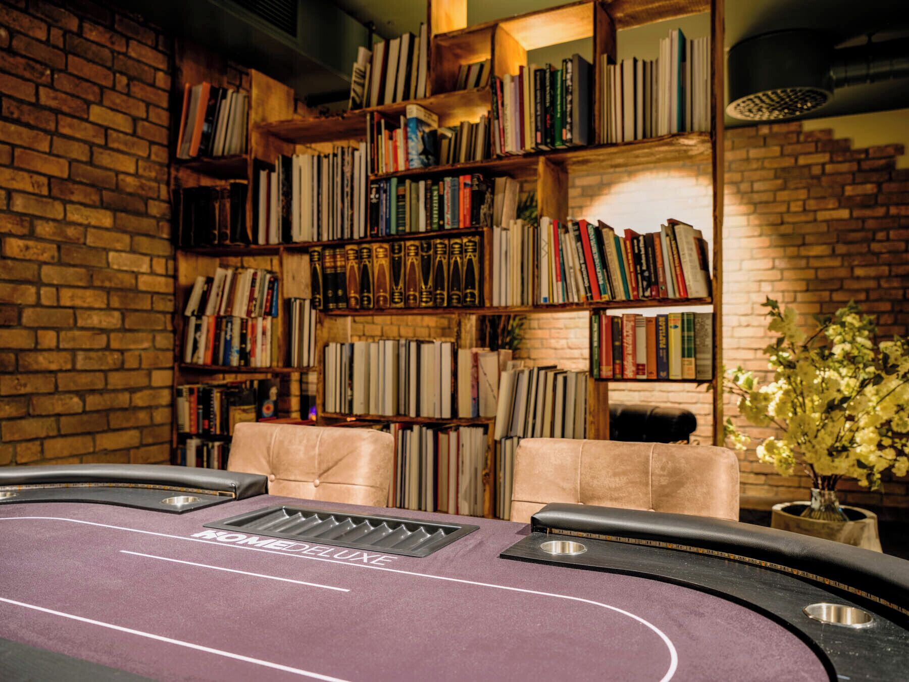 A room with a purple carpet, a fireplace, and bookshelves filled with books.
