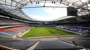 Un estadio con múltiples niveles de asientos, un campo central y una gran estructura de techo.