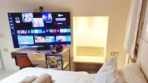 A hotel room with a bed, a TV, and a desk. - The 5 Schei De Mona Concierge Services in Venice (Venice)