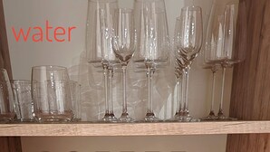 A wooden shelf with various glassware, including wine glasses, coffee cups, and tea cups. - The 5 Schei De Mona Concierge Services in Venice (Venice)